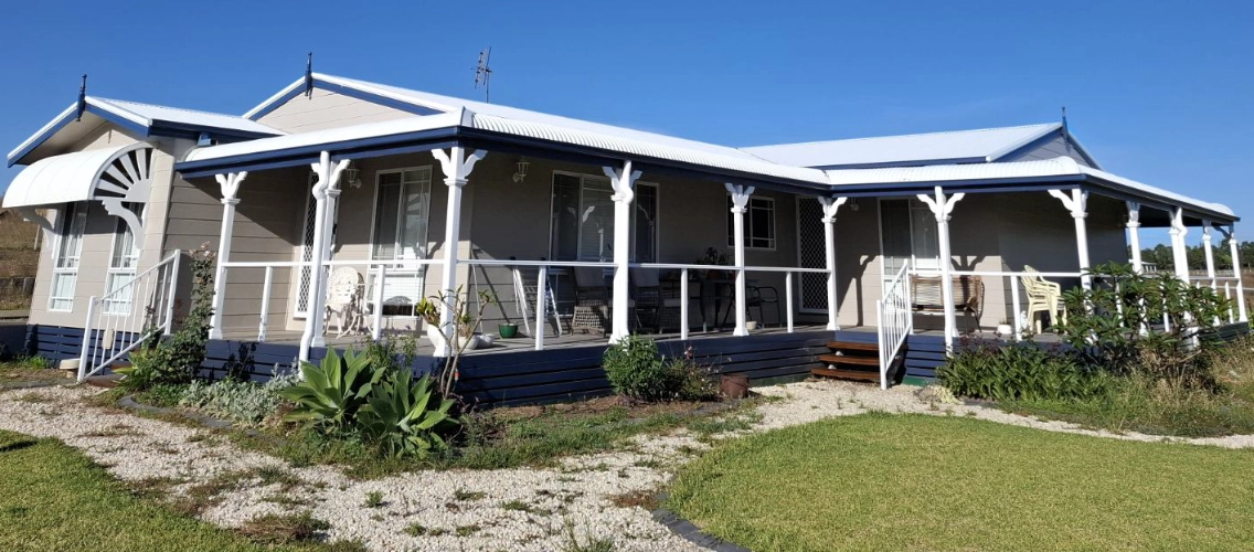 Exterior house with white walls, white posts, and blue accents.