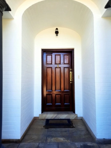 Wooden door set in an arch painted white.